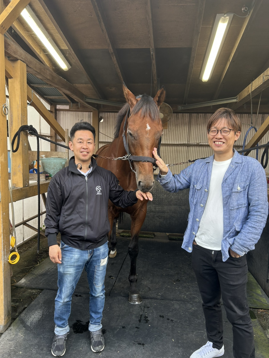 厩舎で馬と調教師との交流